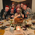Gezin die kerst aan het vieren is, met de Boers&Boers kalkoen op het midden van de tafel