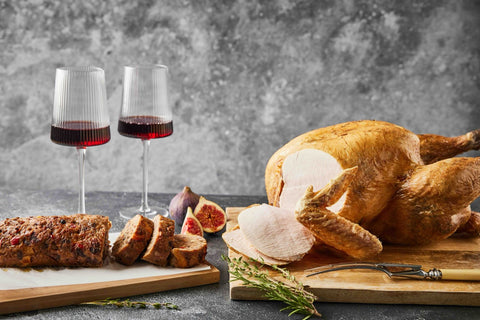 kalkoen op een houten snijplank. Met twee glazen wijn